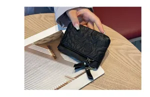Black genuine leather coin purse with embossed camellia flower pattern and double zippers.