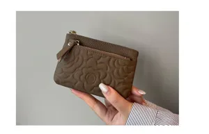 Genuine leather coin purse for women, compact card holder with stylish embossed flower design.