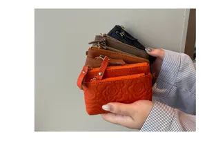 Detail view of genuine leather coin purse with chic camellia embossing, compact card wallet.