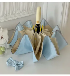 Parapluie pliant avec coins arrondis et protection UV pour les jours de soleil et de pluie.