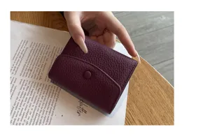 Gros plan sur le porte-cartes minimaliste en cuir véritable pour femme en violet foncé.
