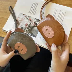 Mini leather coin purse for women, cute pig design, trendy daily wallet with wrist strap.