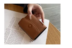 Gros plan d'un porte-cartes en cuir marron montrant sa texture fine et son design accordéon.