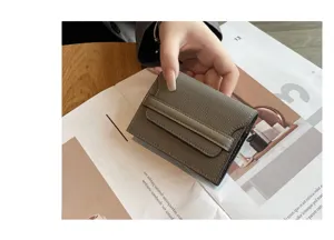 Detailed view of a minimalist grey leather card holder wallet with strap, compact and stylish.