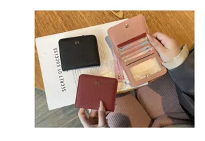 Detail view of genuine leather short women wallet with metal H clasp and multiple card slots.