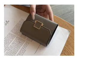 Détail porte-cartes en cuir compact, design élégant à trois volets avec boucle métallique.