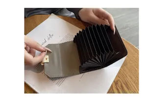 Porte-cartes en cuir accordéon avec multiples fentes et fermoir métallique pour rangement.