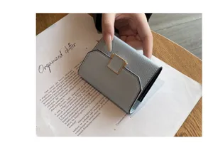 Vue détaillée du portefeuille compact en cuir bleu clair avec fermoir carré en métal.