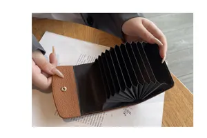 Gros-plan d'un porte-cartes accordéon compact en cuir véritable avec fentes multiples.
