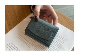 Detailed view of women's genuine leather trifold mini wallet with coin pocket and card slots.