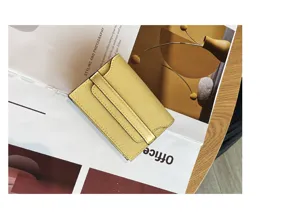 Yellow leather card holder detail showcasing fine texture, compact multi-slot minimalist design.