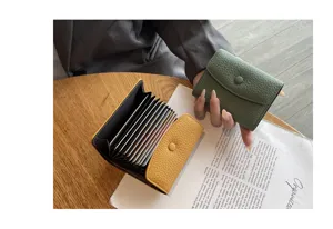 Vue de détail du porte-cartes en cuir véritable avec compartiments accordéon et bouton-pression.