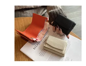 Compact genuine leather trifold wallet for women with RFID coin pocket and card slots.