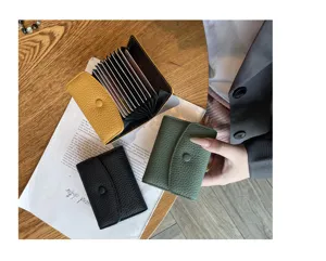 Vue détaillée d'un porte-cartes accordéon en cuir véritable avec fentes multiples et bouton pression.