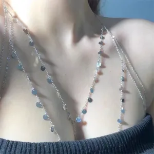 Detail shot of a multi-layer sequin body chain, delicate metal coin necklace for women.