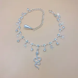Close-up detail of silver rhinestone snake pendant anklet with charming bow decorations.