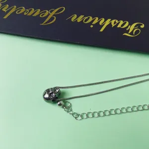 Silver skull pendant necklace with snake chain, gothic punk style fashion jewelry detail.