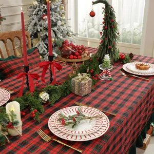 Détail de nappe de Noël à carreaux rouge et vert, tissu en coton mélangé avec bord volant pour déco.