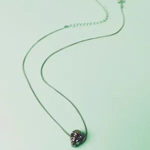 Detailed view of the metal skull pendant snake chain necklace, showcasing delicate design.