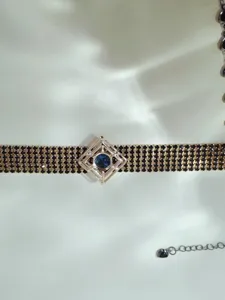 Detailed view of trendy geometric rhinestone choker necklace with blue center stone and extension chain.