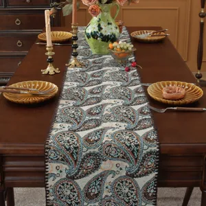 Primo piano dettagliato del runner da tavola jacquard paisley con bordi a conchiglia.