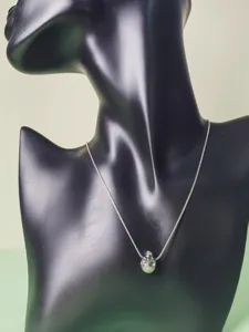 Silver snake chain necklace featuring a delicate mini skull pendant, elegant light luxury jewelry.