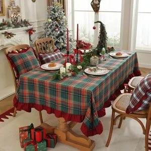 Vue détaillée de la nappe de Noël à carreaux et coussin, ambiance de décoration de fête.