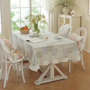 Patchwork tablecloth detail with floral jacquard and ruffled skirt in a cozy dining room.