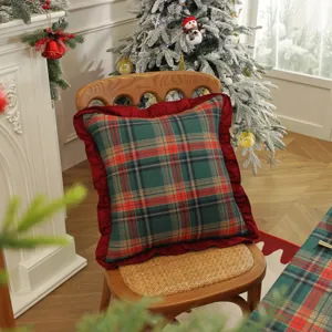 Housse de coussin décorative à carreaux rouges et verts de Noël avec bordure à volants.