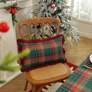 Coussin de décoration de Noël à carreaux rouge et vert avec bordure à volants.