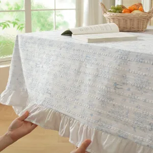 Rustic cotton jacquard tablecloth with floral print and white ruffled hem design.
