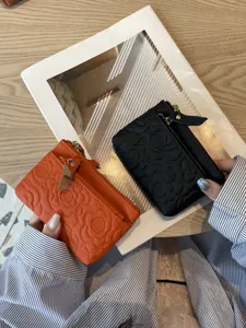 Compact genuine leather coin purse with embossed floral design, multi-card slots and secure zip.