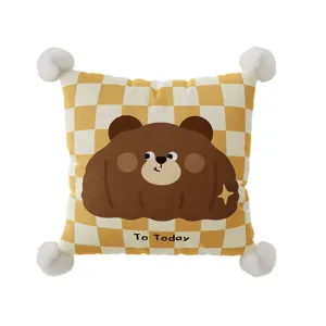 Close-up detail of the cute cartoon bear throw pillow featuring checkerboard pattern and pom-poms.