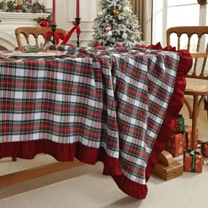 Vue détaillée de la nappe à carreaux de Noël avec bordure à volants rouges pour décoration.