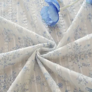 Close-up of pastoral style cotton jacquard fabric with blue floral print and cute stripes.