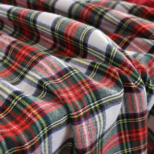 Vue détaillée du tissu à carreaux rouge et vert de Noël, en mélange coton-polyester de qualité.