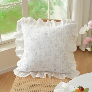 Ruffle edge decorative pillow cover with blue floral print, elegant pastoral style fabric.