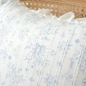 Close-up of pastoral style cotton floral printed fabric with elegant ruffles and bow detail.