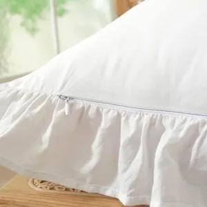Close-up detail view of white cotton tablecloth featuring delicate ruffles and zipper design.