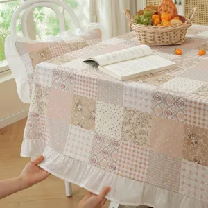 Detailed view of American cotton patchwork tablecloth with cute ruffled skirt edge and cozy home decor.