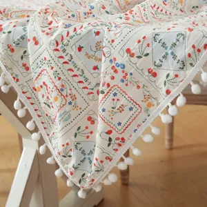 Pastoral style cotton jacquard tablecloth with floral prints and cute white pom-poms detail.