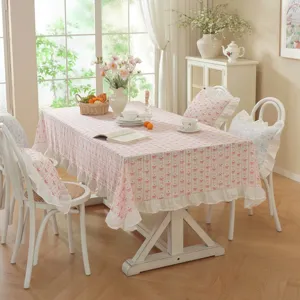 Detail view of pastoral style pink bow floral printed tablecloth with elegant ruffled edge.