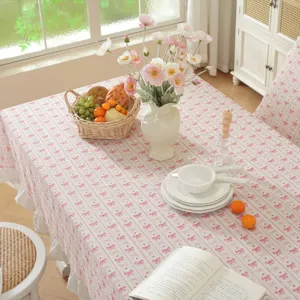 Cottagecore pink cotton tablecloth with cute bow print and elegant ruffles for dining.