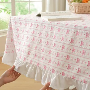 Pastoral cotton tablecloth featuring pink bow pattern and delicate white ruffled edge.