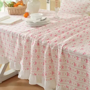 Pastoral cotton tablecloth with pink bow print and white ruffles, elegant home decor detail view.