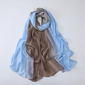 Detailed view of lightweight blue and brown gradient chiffon hijab scarf draped on white