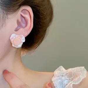 Nahaufnahme Detailansicht von rosa Harz Rosen Blumen Ohrringen am Ohr, elegant und süß.