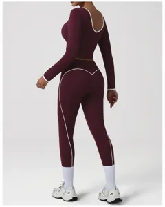 Completo yoga da donna bordeaux con crop top a maniche lunghe e leggings, profili bianchi.