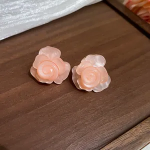 Nahaufnahme von rosa Harz Rosen Blumen Ohrringen mit detaillierten Blütenblättern, Schmuck.