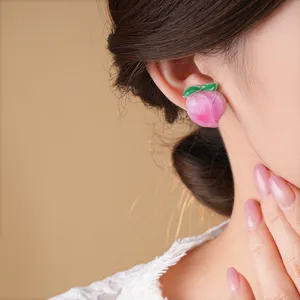 Nahaufnahme Detail süßer Pfirsich Harz Ohrstecker, rosa Frucht Design für den Frühling.